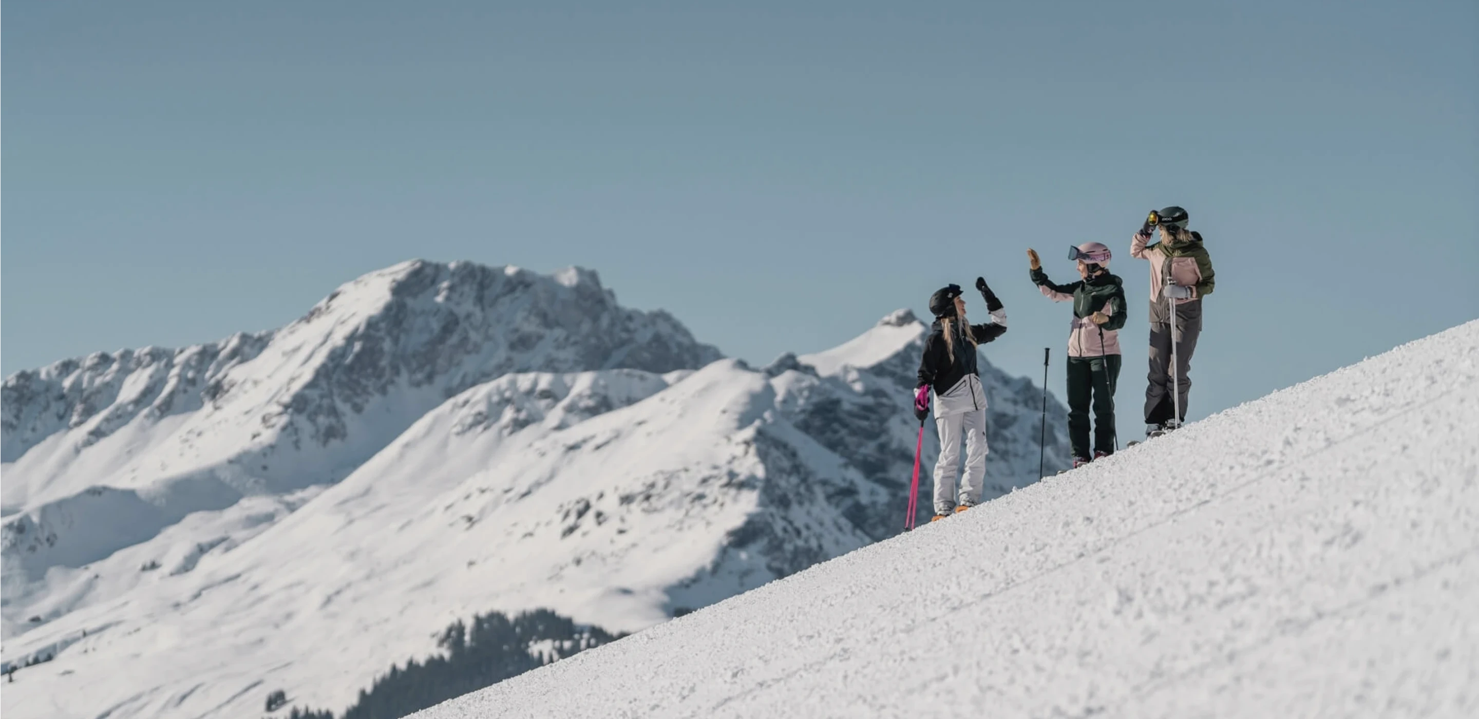 Wintersporters met bergen op de achtergrond en witte piste
