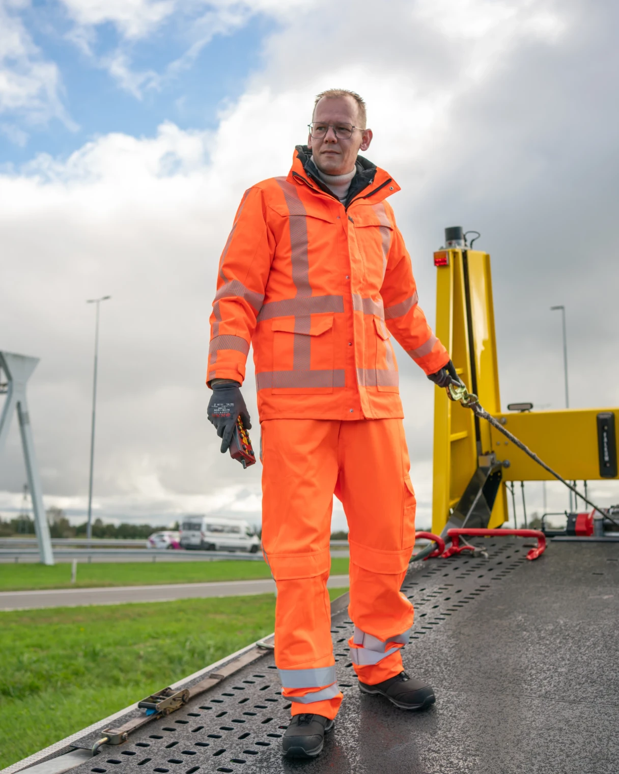 Chauffeur in oranje werkkleding op een takelwagen